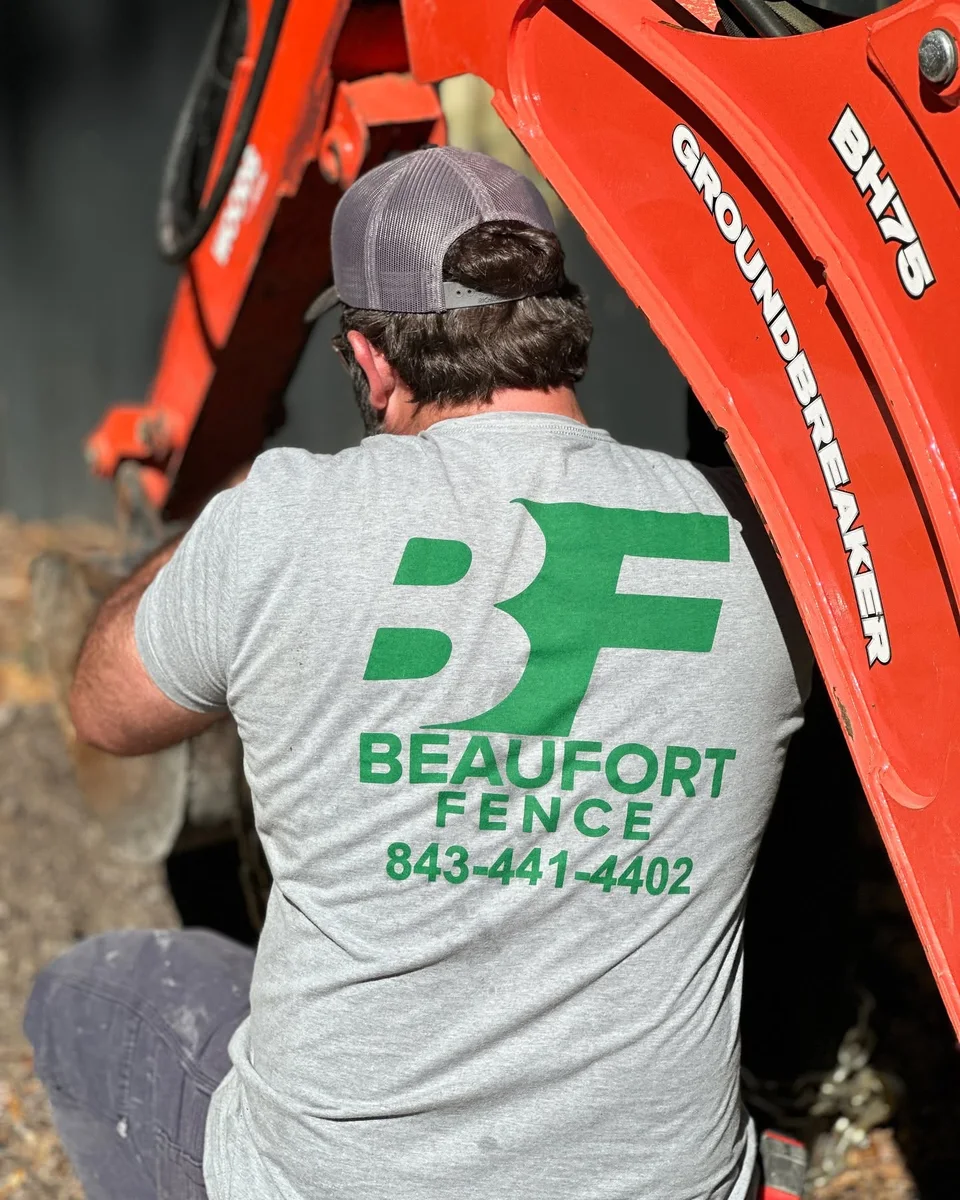 Jason Davis at work in a Beaufort Fence shirt beside orange equipment