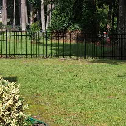 Open metal fence in a wooded Beaufort Fence project