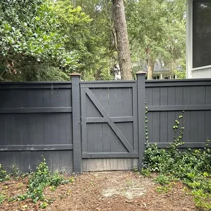 Dark painted wood privacy fence with a matching cross-braced gate