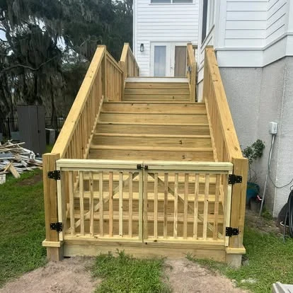 Wood stairs with matching handrails and a picket gate at the bottom