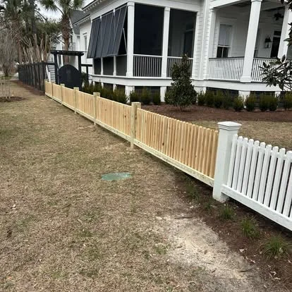 Open wood picket fence beside a home
