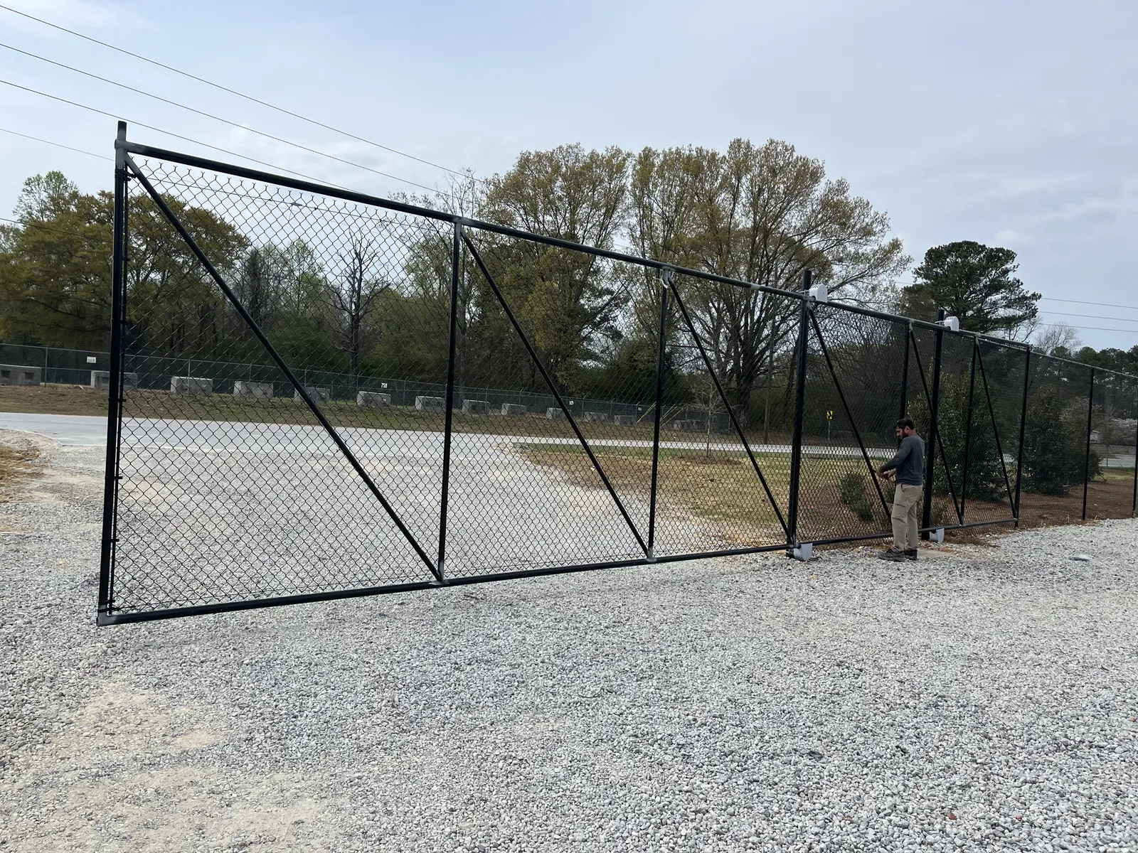 Wide chain-link access gate at a working property; shared-library design reference